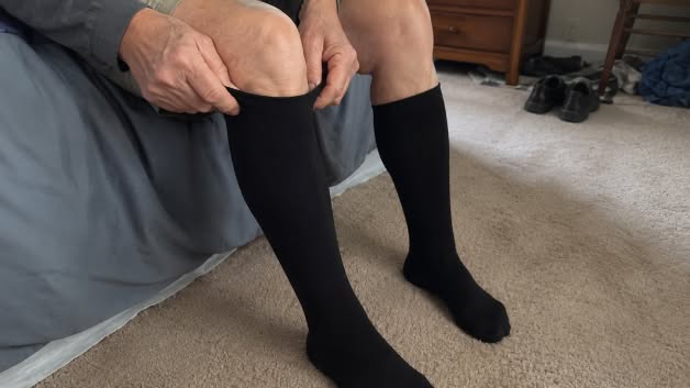 Person pulling a TrueFit compression sock up over the calf
