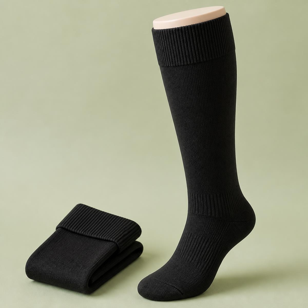 Pair of black TrueFit knee-high compression socks showing the wide ribbed comfort cuff and fine knit